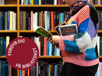 Foto af kvinde på bibliotek med bøger i hånden